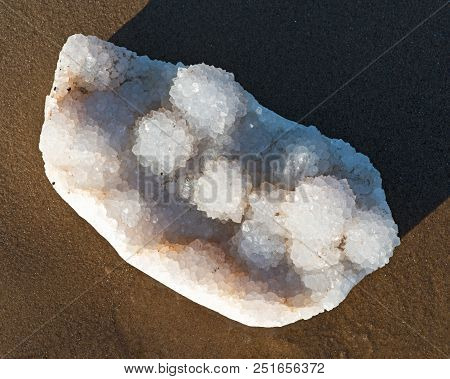 Aurora Rainbow Quartz Cluster From India    On Wet Sand  In Front Of The Lake At Sunrise.