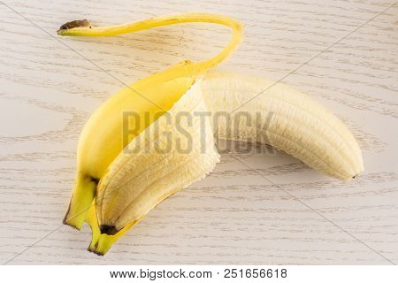 One Whole Opened Fresh Yellow Banana Flatlay On Grey Wood