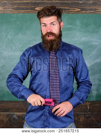 School Accident Prevention. Teacher Bearded Man With Pink Stapler Chalkboard Background. School Stat