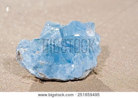 Blue Celestite Cluster From Madagascar On Wet Sand On The Beach At Sunrise.