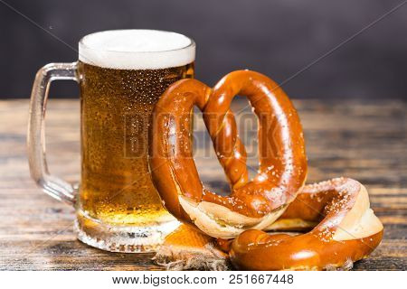 Alcohol, Liquid, Food Concept - A Huge Cup Of Beer On A Table With A Bagel.