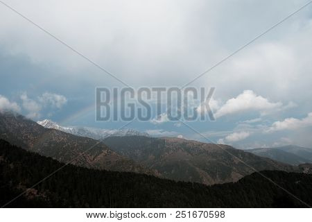 Panorama Of The Rainbow Against The Background Of Snow-capped Mountains In The Clouds