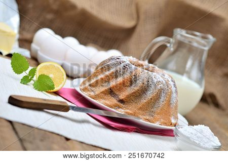 Homemade Lemon Bundt Cake Sprinkled With Sugar, Milk, Eggs, Melissa Leaves, And Butter, Still Life W