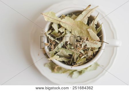 Dried Lime Flower Tea. Herbal Drink. Tilia Flowers And Leaves In A White Cup, Top View
