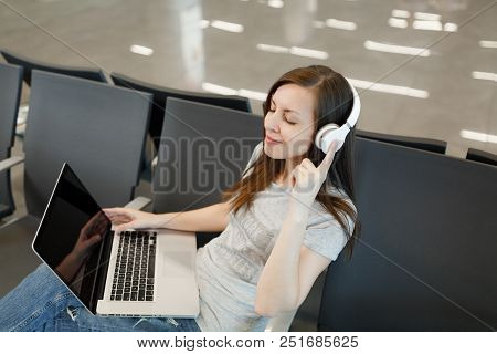 Young Relaxed Traveler Tourist Woman With Headphones Listen Music Working On Laptop With Blank Scree