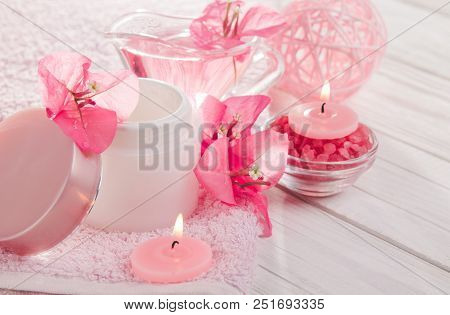 Spa Set With Cream, Towel, Candles, Salt And Flowers On Wooden Background. Organic Cosmetics