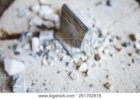 Close up shot of metal tool on concrete floor with stone shards scattered around, copy space