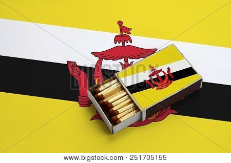 Brunei Darussalam Flag  Is Shown In An Open Matchbox, Which Is Filled With Matches And Lies On A Lar