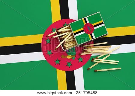 Dominica Flag  Is Shown On An Open Matchbox, From Which Several Matches Fall And Lies On A Large Fla