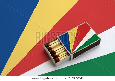 Seychelles Flag  Is Shown In An Open Matchbox, Which Is Filled With Matches And Lies On A Large Flag