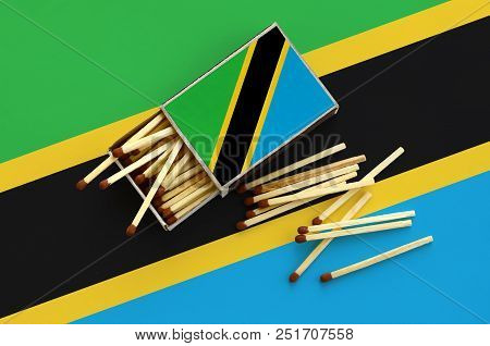 Tanzania Flag  Is Shown On An Open Matchbox, From Which Several Matches Fall And Lies On A Large Fla