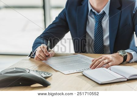 Cropped Shot Of Businessman Signing Contract At Wokplace