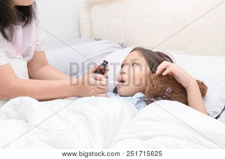 Mother Giving Her Daugther Syrup