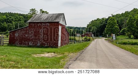 Claysville, Pennsylvania/usa- June 8, 2018:  Faded Red Barn On A Country Road In Rural Appalachia.