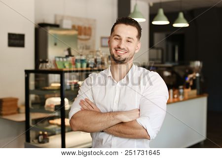 Young Administrator Standing With At Cafe And Wearing White Shirt.