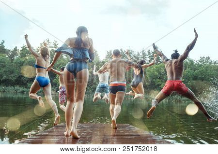 Enjoying Forest Party With Friends. Group Of Beautiful Happy Young Men And Girls Swimming At The Riv