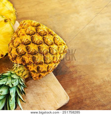 Pineapple On Wood Texture Background. Whole And Sliced Tropical Pineapple On Wooden Cutting Board  W