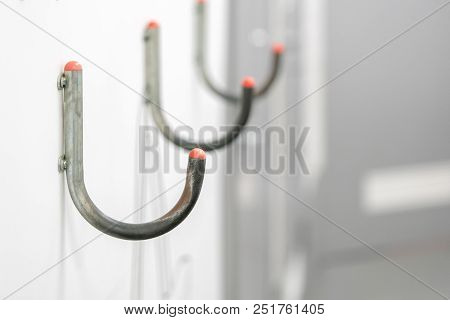 A Series Of Hooks For Bags Is Attached To The Wall Of A Supermarket.