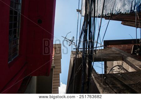 Low Angle Photo Ofl Worn Houses And Wires Of A Favela In Brazil.