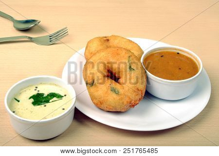 Sambar vada or Medu vada is a very popular South Indian food on wooden background
