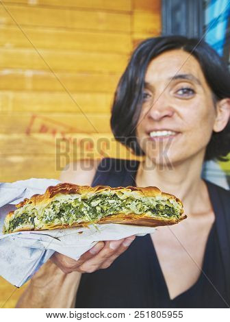 Greek Woman Eating A Traditional Spanakotiropita, Spinach And Feta Pie.