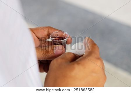 Adult And Faithful In Jesus Christ Man In A Holy Communion. Pray With Holding Loaf And Little Cup Of