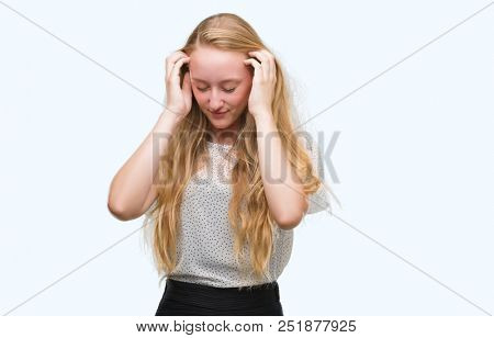 Blonde teenager woman wearing moles shirt with hand on head for pain in head because stress. Suffering migraine.