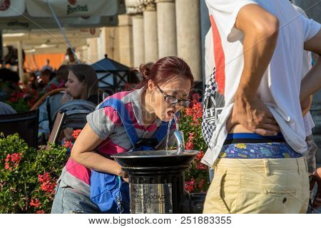 Cracow, Poland - July 5, 2018: Woman Is Refreshing At Fountain In Sweltering Hot Days On Main Square