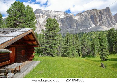 Sella Group Mountains Viewed From A Hiking Path Near Sella Pass With A Mountain Hut In The Foregroun