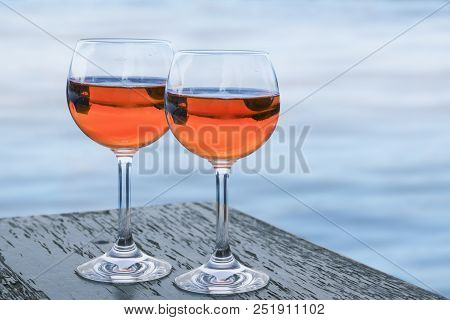Spritz Aperol Veneziano In Two Glasses On A Table Against The Blue Sea, A Popular Cocktail, Alcoholi