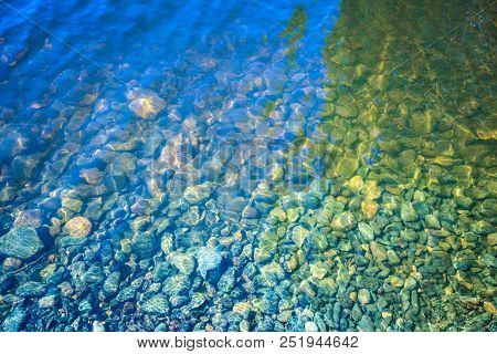 The Texture Or Background Of The Stones And Little Fishes In The Water Of The Lake, River Or The Sea