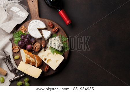 Wine, cheese, grape, bread and nuts. Top view with space for your text