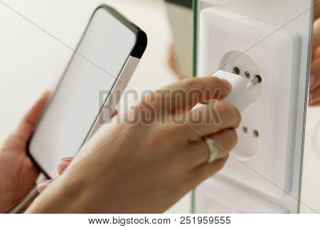 While Charging The Battery Mobile Phone Hand Pluging Adapter With Outlet Socket Plug And Hold Mobile