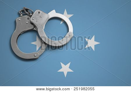 Micronesia Flag  And Police Handcuffs. The Concept Of Crime And Offenses In The Country