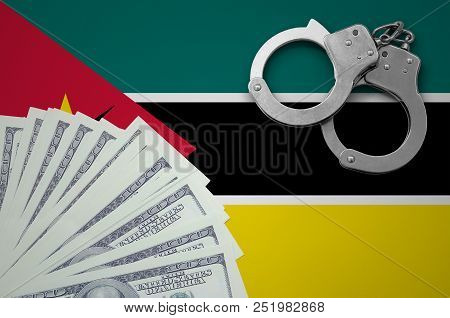 Mozambique Flag  With Handcuffs And A Bundle Of Dollars. The Concept Of Illegal Banking Operations I