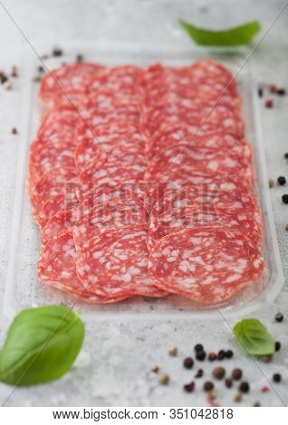 Pack Of Lassic Salami Slices With Basil And Pepper On Light Background.