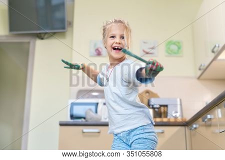 Adorable Cute Caucasian Little Blond Girl Enjoy Having Fun Painting With Brush And Palm At Home Indo