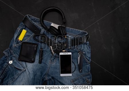 Men's jeans and attributes. Headphones and player. Top.