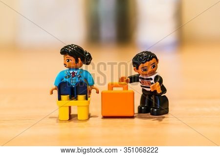 Poznan, Poland - February 16, 2020: Lego Duplo Thief Trying To Steal A Orange Suitcase From A Sittin