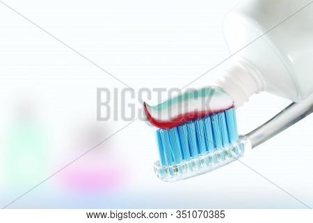 Toothbrush And Toothpaste On Blurred Background. Care For The Oral Cavity And Teet