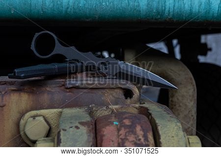 Black Metal Knife For The Military. Military Knife On A Military Car. Green Hitch Car.