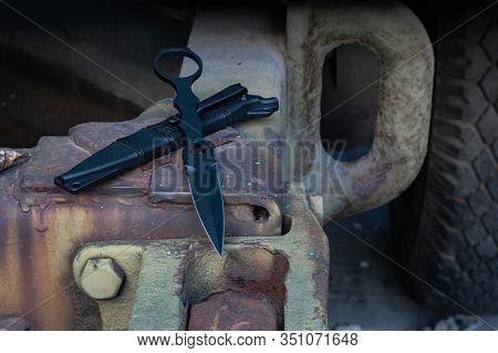 Knife With An Iron Handle And Emphasis Under The Fingers. Plastic Sheath. Front View.