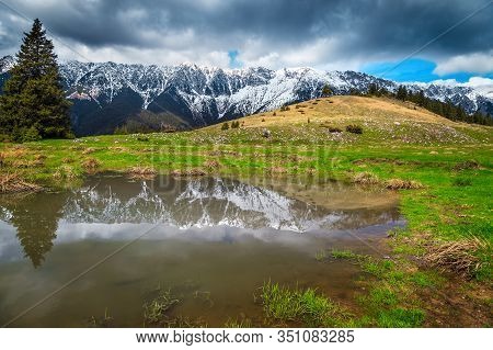 Beautiful Alpine Scenery With Small Lake And High Snowy Piatra Craiului Mountains, Near Pestera Vill