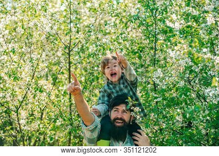 Fathers Day. Father And Son On Spring Blossom Garden Background. Beautiful Young Smiling Family Havi