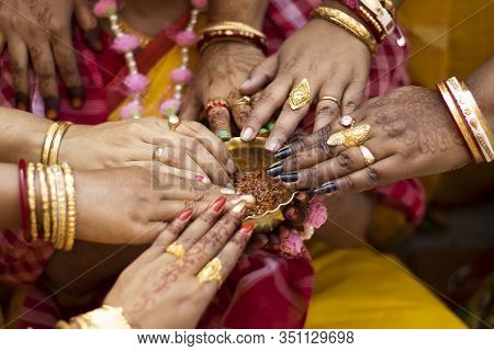 Indian Bride And Women Hands Holding Brass Bowl Of Turmeric