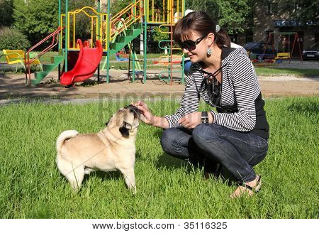 Mopsz kutya és fiatal nő