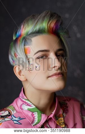 Portrait Of A Young Beautiful Girl In A Pink Shirt On A Gray Background With Dyed Hair. Short Haircu