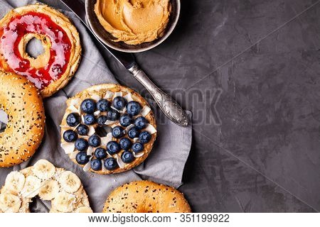 Variety Of Bagels With Different Toppings And Natural Paleo Nut Peanut Cashew Creamy Butter On Dark 