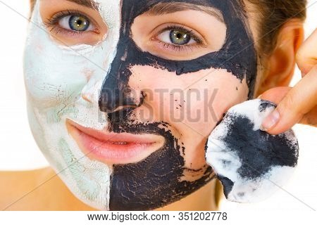 Woman With Clay Carbo Black Mask On One Half Face And White Mud On Second Half. Girl Removing Cosmet
