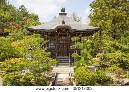 Photograph Of The Front Of A Japanese Wooden Temple Surrounded By Plants